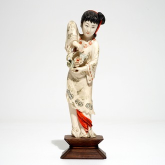 A Chinese polychrome ivory figure on wooden stand, 2nd quarter 20th C.