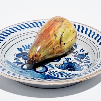 A polychrome Dutch Delft trompe l'oeil plate with a pear, 19th C.