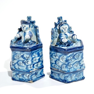 A pair of Dutch Delft models of seated children, 18th C.