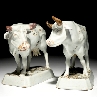 A pair of large cold-painted white Dutch Delft cows on bases, 18th C.