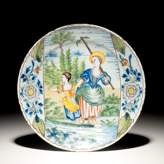 Une assiette en faïence polychrome de Delft à décor d'une femme et sa fille au travail, 18ème