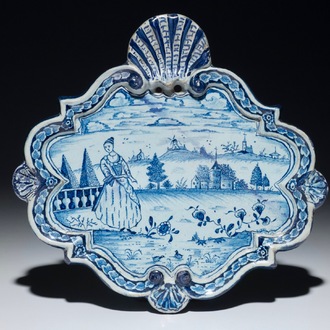 Une plaque en faïence de Delft bleu et blanc à décor d'une femme dans un paysage, 18ème