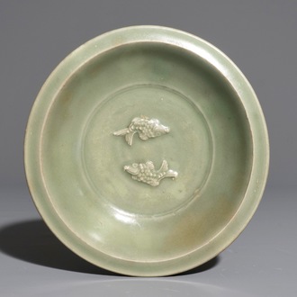 Een Chinees Longquan celadon bord met decor van twee vissen, Ming