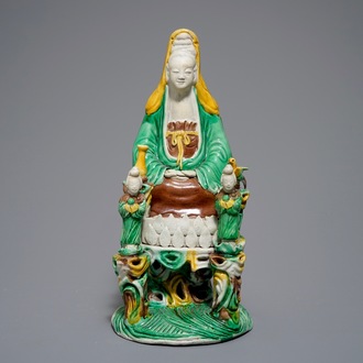 A Chinese verte biscuit group of Guanyin on a lotus throne, 18th C.