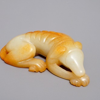 A Chinese carved russet jade model of a reclining dog, 19/20th C.