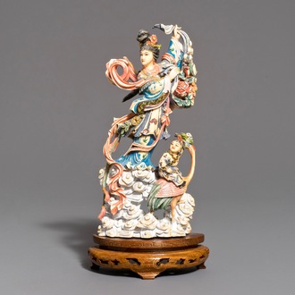 Een Chinese polychrome ivoren figuur van Magu op houten sokkel, 1e helft 20e eeuw