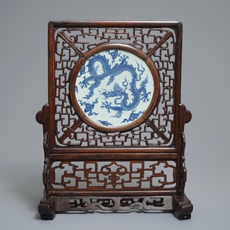 A Chinese carved wood table screen with a blue and white dragon medallion, Ming and 19th C.