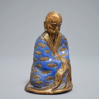 A Chinese champlevé enamel and gilt copper model of a Luohan, Qianlong