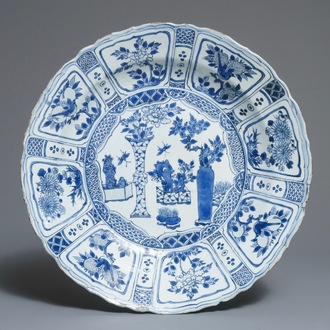 Un grand plat en porcelaine de Chine bleu et blanc de type kraak à décor d'un arrangement de vases, Wanli