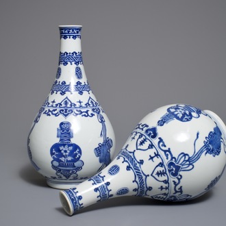 A pair of Chinese blue and white bottle vases with ribbons and precious objects, Kangxi