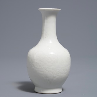 Un vase de forme bouteille en porcelaine blanc de Chine à décor floral incisé, vers 1900