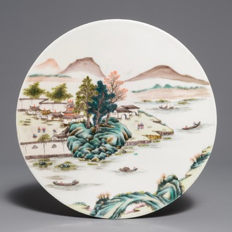 Une plaque ronde en porcelaine de Chine famille rose à décor d'un paysage, 19/20ème