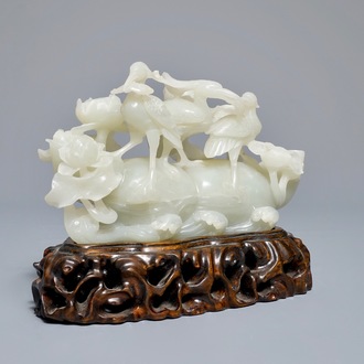 A Chinese celadon jade 'cranes' group on carved wooden base, Qing