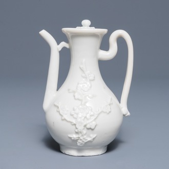 A Chinese Dehua blanc de Chine wine jug and cover with applied floral design, Kangxi