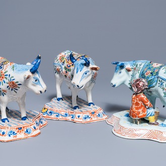 A pair of polychrome Dutch Delft models of cows and one with a milker, 19th C.