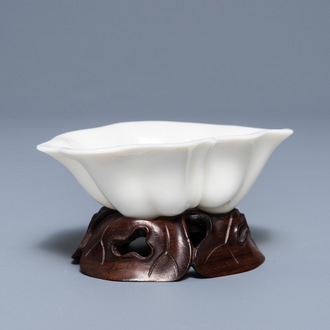 A Chinese Dehua blanc de Chine lotus leaf-shaped brush washer on stand, Kangxi