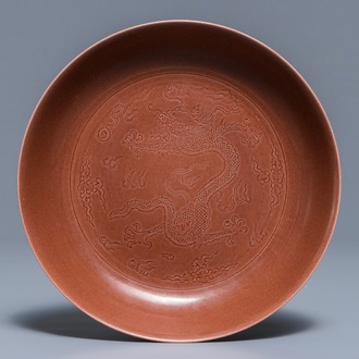 Un plat en porcelaine de Chine aubergine monochrome à décor incisé d'un dragon, marque et époque de Jiaqing