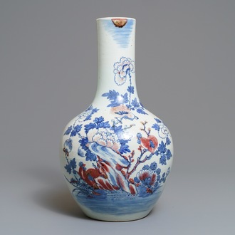 Un vase en porcelaine de Chine bleu, blanc et rouge à décor de coqs, 19ème