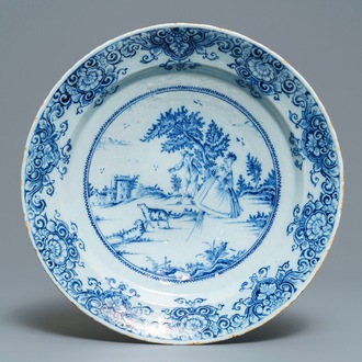 A Dutch Delft blue and white dish with a couple playing blind man's buff, 18th C.