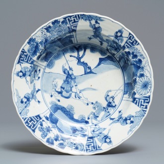 Een Chinees blauwwit bord met strijders te paard, Kangxi merk en periode