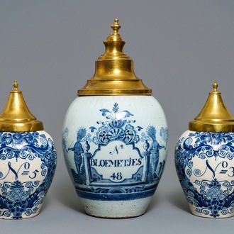 Three Dutch Delft blue and white tobacco jars with brass covers, 18th C.