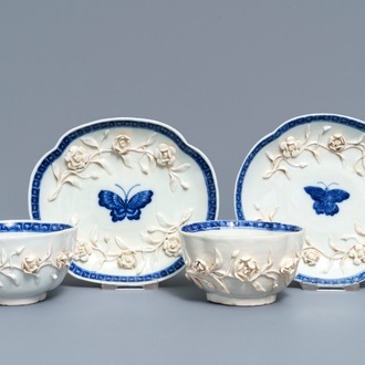 A pair of Chinese blue and white 'soft paste' relief-decorated cups and saucers, Qianlong