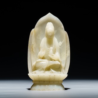 Een Chinese celadon jade figuur van Guanyin op lotustroon, 19/20e eeuw