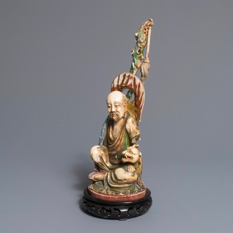 A polychrome Chinese ivory group of a sage with a tiger, 19/20th C.