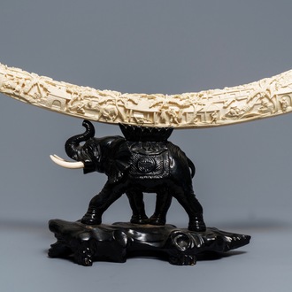 A Chinese carved ivory tusk on wooden elephant stand, ca. 1900