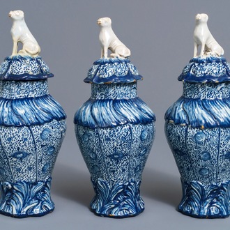 Three Dutch Delft blue and white dog-topped vases and covers, 18th C.
