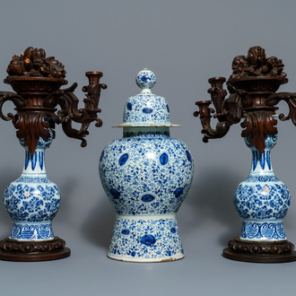Une garniture de trois vases en faïence de Delft bleu et blanc aux montures en bois, 18ème