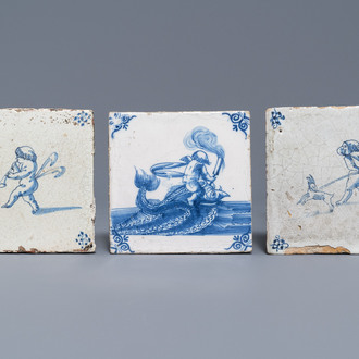 Drie blauw-witte Delftse tegels met putti en een zeemonster, 17e eeuw