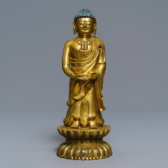 Een Chinese verguld bronzen figuur van een staande Boeddha met inscriptie, Qianlong