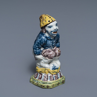 A rare polychrome Dutch Delft caster in the shape of a pooping man, 18th C.