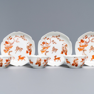 Three Chinese iron red eggshell cups and saucers with boys and goats, Yongzheng