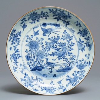 Un plat en porcelaine de Chine bleu et blanc à décor d'oiseaux parmi branches fleuries, époque Transition