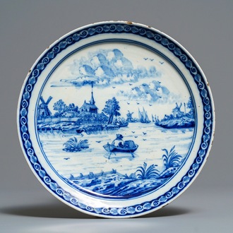 Een blauw-wit Delfts bord met een fijn rivierlandschap, 18e eeuw