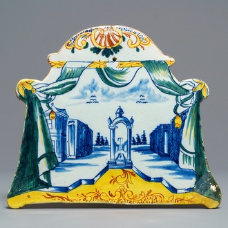 Une plaque en forme de tente entourée d’une draperie à décor d'un paysage en faïence polychrome de Delft, 18ème