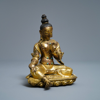 A Sino-Tibetan coral- and turquoise-inlaid gilt bronze figure of Tara, 18th C.