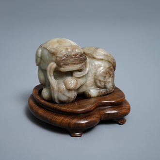 Een Chinees grijs-bruin jade model van een Boeddhistische leeuw, 19/20e eeuw