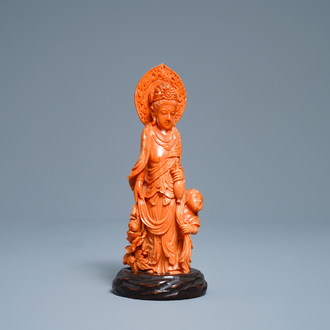 A Chinese carved red coral group of Guanyin with child, 19th C.