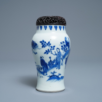 Un vase en porcelaine de Chine en bleu et blanc à décor de figures dans un paysage, époque Transition