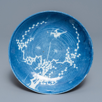 Une assiette en porcelaine de Chine à décor inverse en blanc et bleu, époque Transition