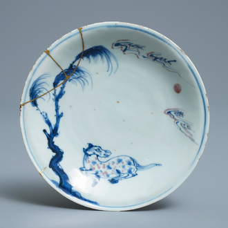 Een Chinees blauw-wit en onderglazuur rood bord met een paard en kintsugi herstelling, Tianqi
