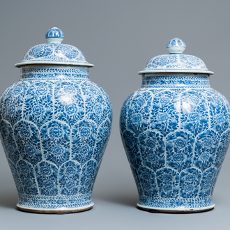 A pair of Chinese blue and white vases and covers with floral design, Kangxi