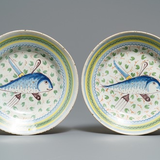 Een paar polychrome Brussels aardewerken borden met vis en bestek, 18e eeuw
