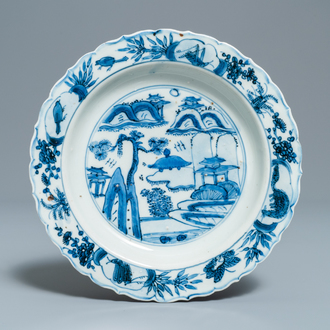 Une assiette en porcelaine de Chine en bleu et blanc de type kraak à décor d'un paysage, Wanli