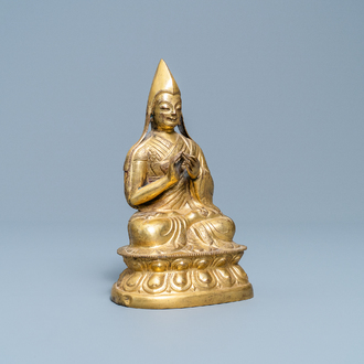 A Sino-Tibetan gilt bronze figure of a Lama, Ming