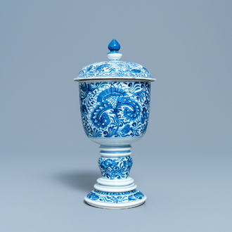 Een Chinese blauw-witte dekselbeker met floraal decor, Kangxi