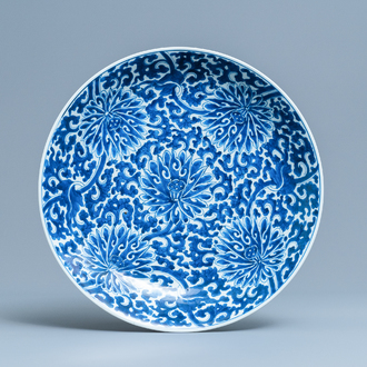 Un plat en porcelaine de Chine en bleu et blanc à décor de rinceaux de lotus, Kangxi
